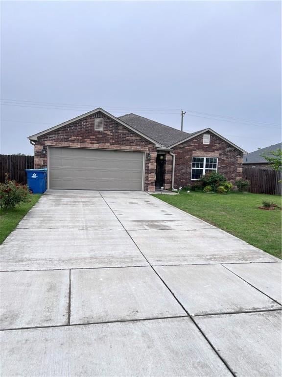 ranch-style home featuring fence, concrete driveway, a front yard, and a garage