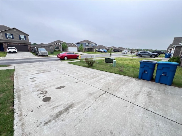 exterior space with a garage, a residential view, and concrete driveway