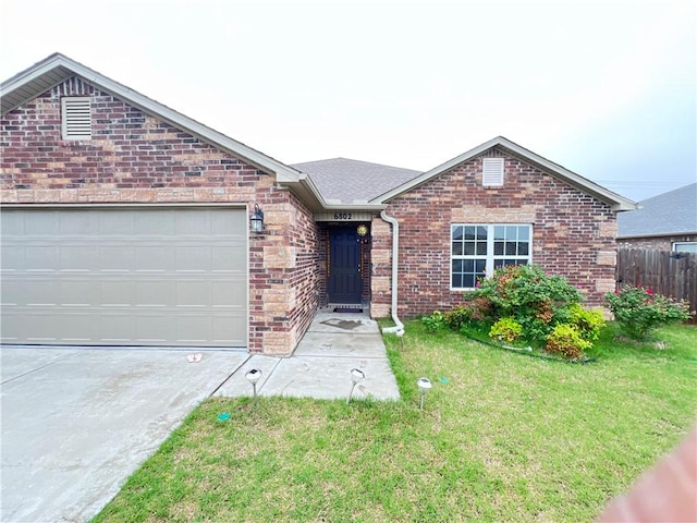 ranch-style home featuring brick siding, fence, a garage, driveway, and a front yard