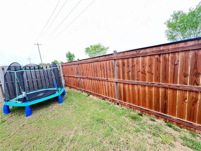 view of yard with a fenced backyard and a trampoline