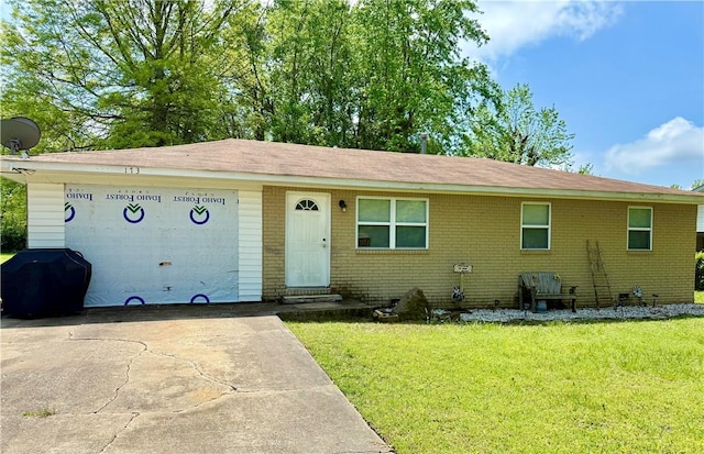 single story home with a front lawn, driveway, and brick siding
