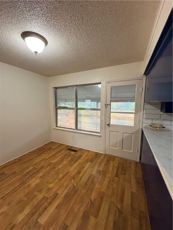 8455 Par Ln, Rogers, AR 72756 - unfurnished room with a textured ceiling, wood finished floors, and plenty of natural light