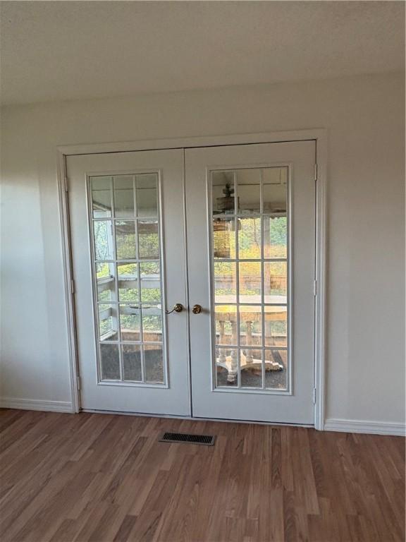 doorway to outside featuring visible vents, wood finished floors, french doors, and baseboards