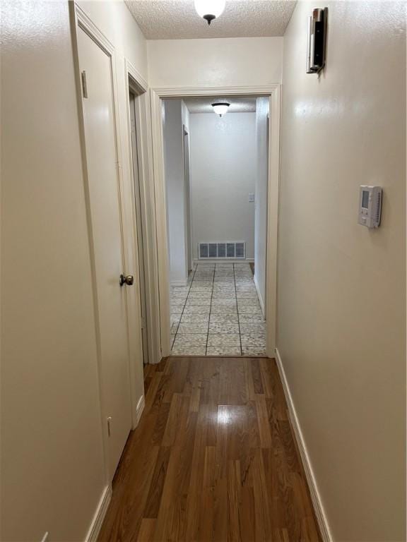 8455 Par Ln, Rogers, AR 72756 - hall with wood finished floors, a textured ceiling, and baseboards