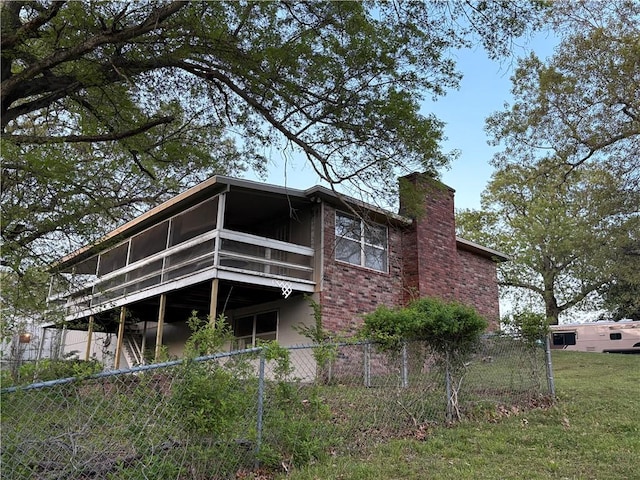 back of property with fence, a chimney, and a sunroom