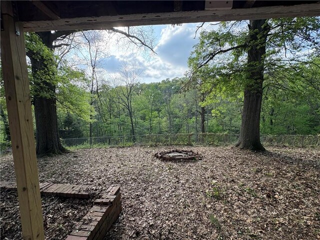 view of yard with fence and a wooded view