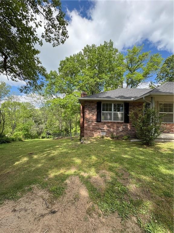 8455 Par Ln, Rogers, AR 72756 - view of side of home featuring brick siding, a lawn, and a chimney
