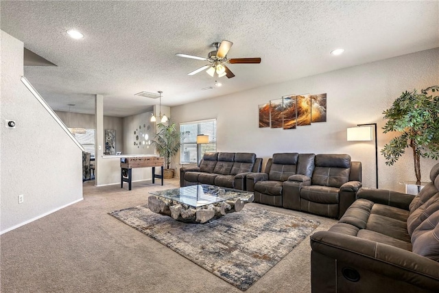 carpeted living area featuring a textured ceiling, a textured wall, and a ceiling fan