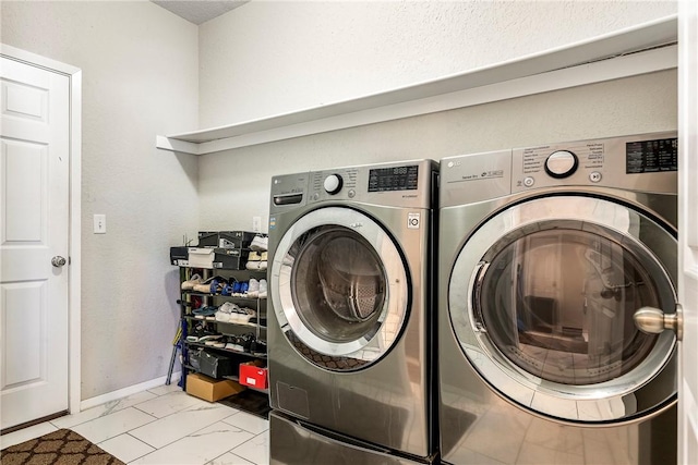 clothes washing area with marble finish floor, washer and clothes dryer, laundry area, and baseboards
