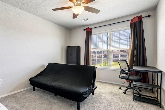 sitting room featuring baseboards, visible vents, carpet floors, and a textured ceiling