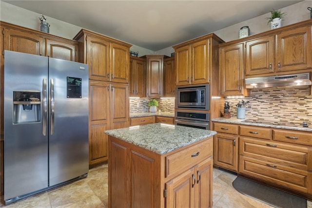 15 Serenity Ln, Holiday Island, AR 72631 - kitchen featuring stainless steel appliances, under cabinet range hood, decorative backsplash, and brown cabinets