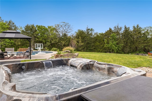 view of patio / terrace with a gazebo, a hot tub, and a fenced in pool