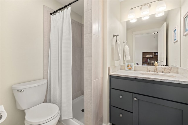 full bathroom featuring a stall shower, toilet, and vanity
