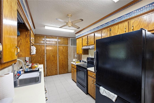 kitchen featuring under cabinet range hood, brown cabinets, black appliances, ceiling fan, and a sink