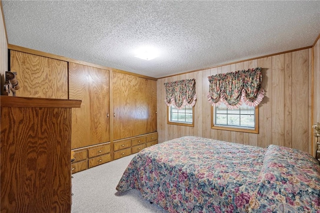 carpeted bedroom with wood walls and a textured ceiling