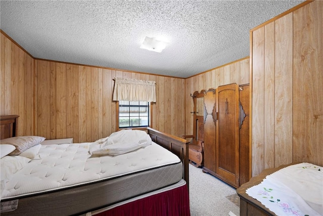 bedroom with crown molding, a textured ceiling, carpet flooring, and wood walls