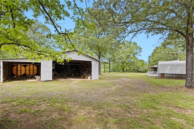 view of yard featuring an outdoor structure, a pole building, and a detached garage