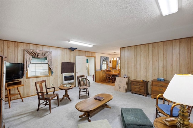 carpeted living area featuring a textured ceiling and wood walls