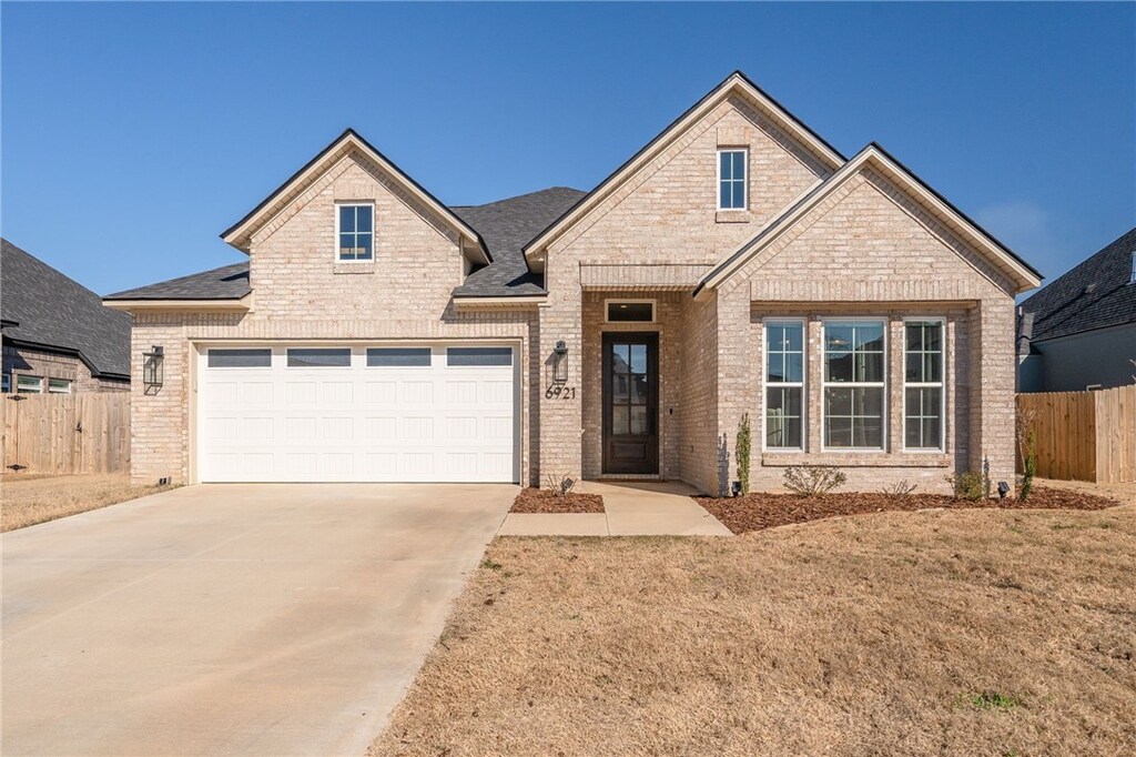 6921 Forest Canyon Dr, Fort Smith, AR 72916 - traditional-style house with brick siding, fence, a garage, a front yard, and concrete driveway