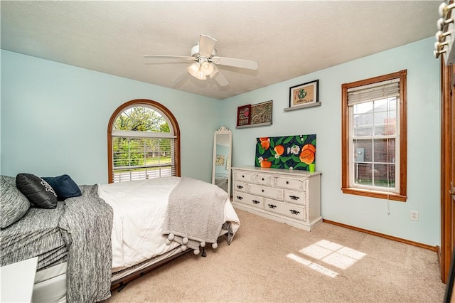 carpeted bedroom featuring baseboards and a ceiling fan