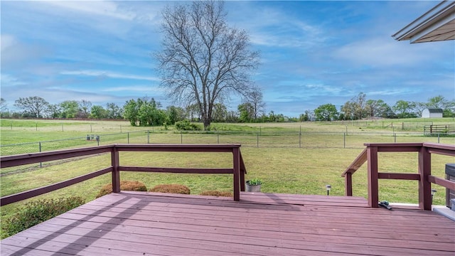 deck with a rural view, a yard, and a fenced backyard