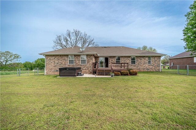 back of house featuring a gate, a fenced backyard, a deck, and a yard