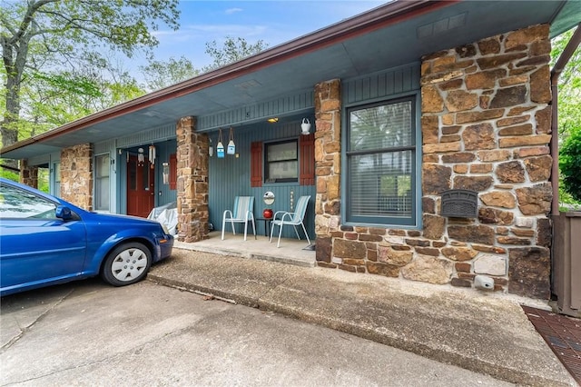 exterior space with covered porch and stone siding
