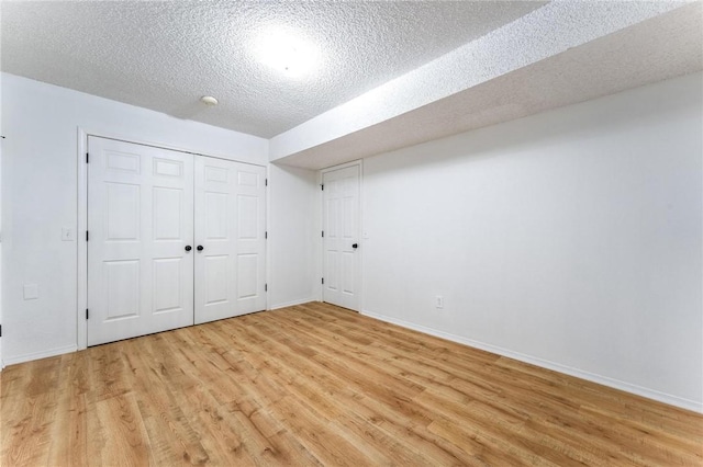 unfurnished bedroom with a closet, light wood-style flooring, and baseboards