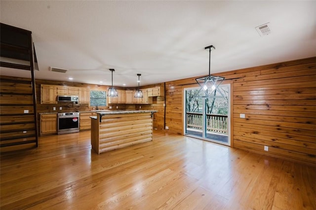 1010 Ashley Ln, Pea Ridge, AR 72751 - kitchen with stainless steel microwave, light wood-style flooring, decorative light fixtures, a kitchen island, and a sink