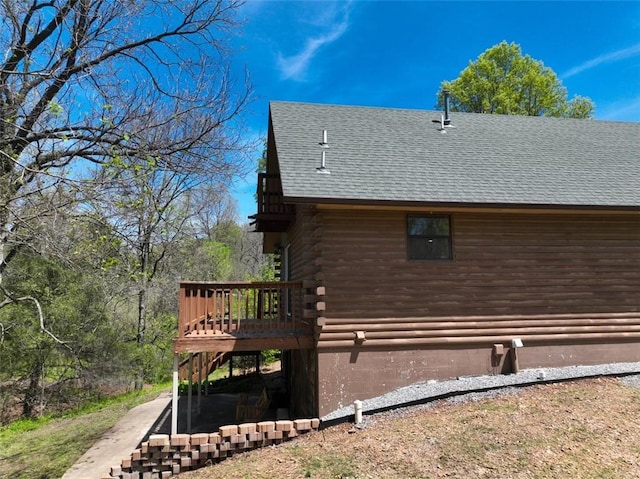 1010 Ashley Ln, Pea Ridge, AR 72751 - view of side of home with log exterior, a deck, a shingled roof, and stairway
