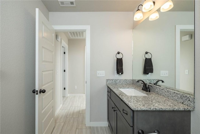 bathroom featuring visible vents, vanity, and baseboards