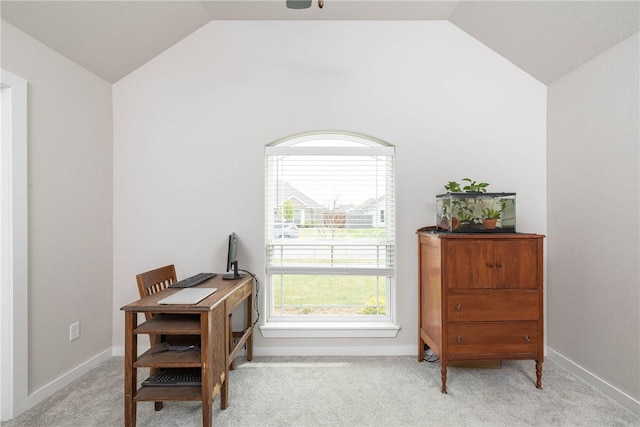 office space featuring lofted ceiling, baseboards, and light carpet