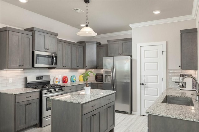 kitchen with light stone countertops, a sink, stainless steel appliances, backsplash, and ornamental molding