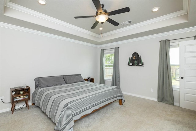 bedroom with visible vents, light carpet, and a tray ceiling