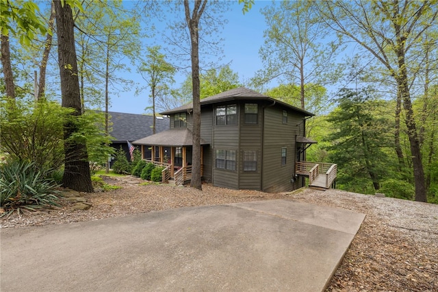 view of front of house with covered porch and a shingled roof