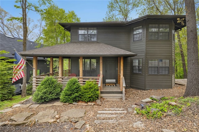 prairie-style house with a porch, roof with shingles, and cooling unit