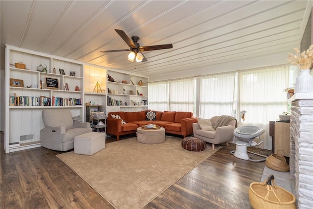 living room featuring visible vents, ceiling fan, dark wood-style floors, and built in shelves