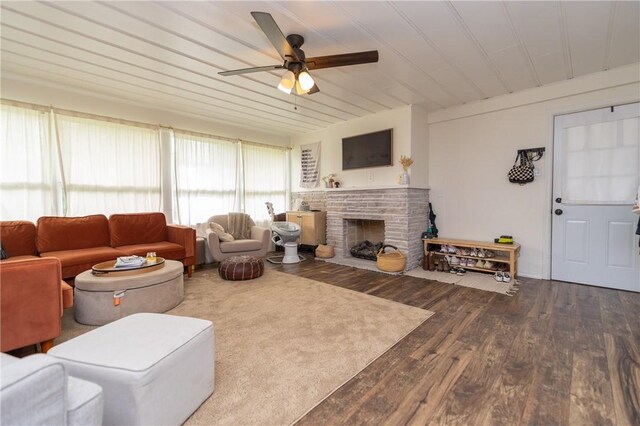 living room featuring wood-type flooring, ceiling fan, and a fireplace with flush hearth