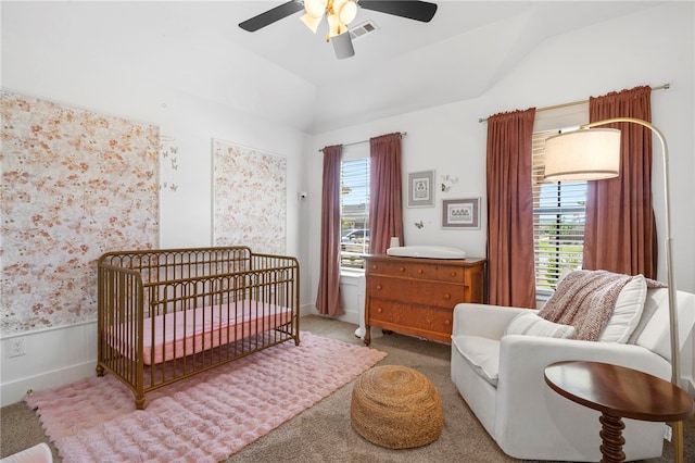 bedroom featuring a nursery area, visible vents, multiple windows, and vaulted ceiling