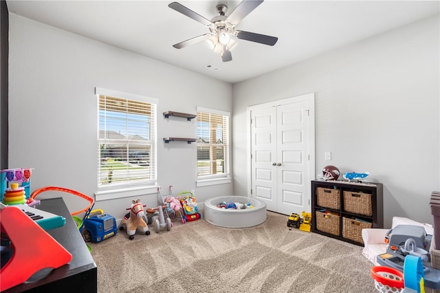 recreation room with a ceiling fan, visible vents, and carpet