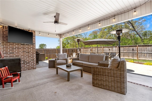 view of patio with outdoor lounge area, a ceiling fan, and a fenced backyard
