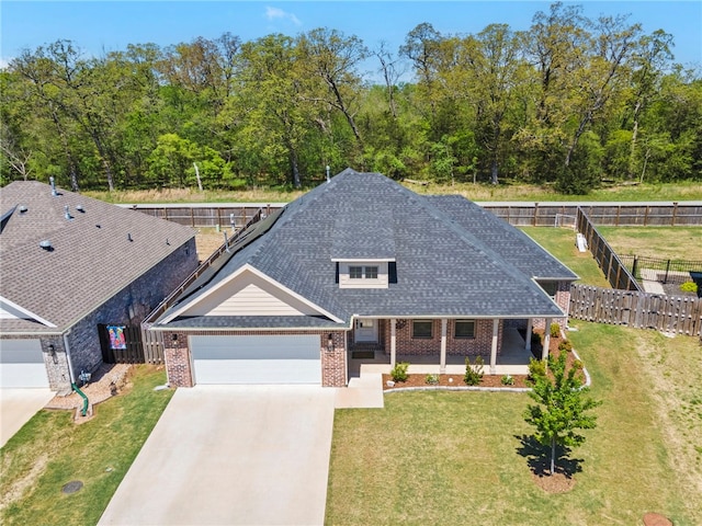 view of front of home featuring fence, a front yard, brick siding, concrete driveway, and an attached garage