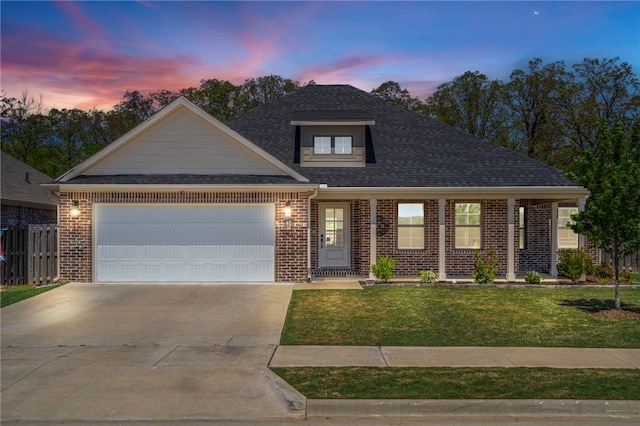 view of front of house with a garage, a front lawn, roof with shingles, brick siding, and concrete driveway