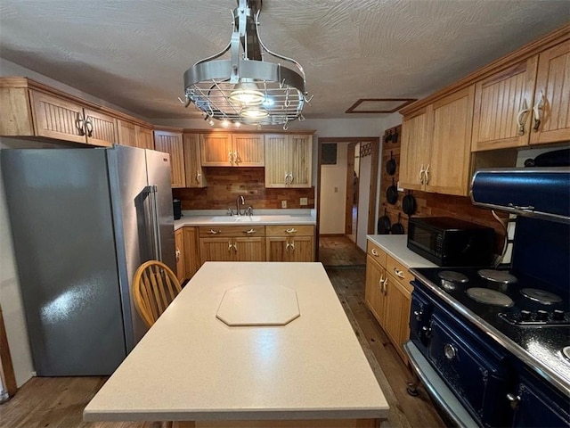 2525 Dustin Ln, Omaha, AR 72662 - kitchen featuring a kitchen island, black microwave, light countertops, freestanding refrigerator, and dark wood-type flooring