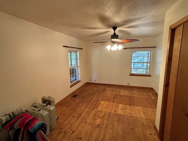 2525 Dustin Ln, Omaha, AR 72662 - empty room featuring plenty of natural light, a ceiling fan, hardwood / wood-style floors, and visible vents