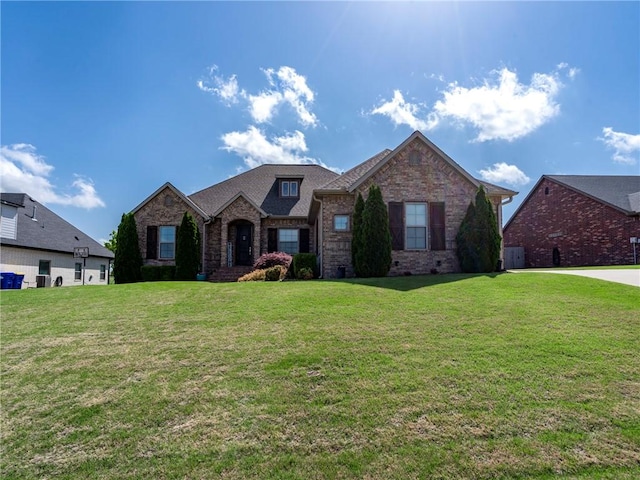 view of front of property with brick siding and a front lawn