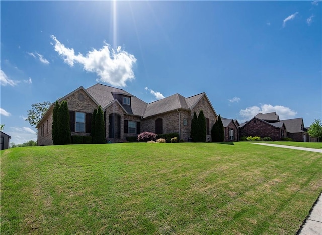 ranch-style house featuring brick siding and a front yard
