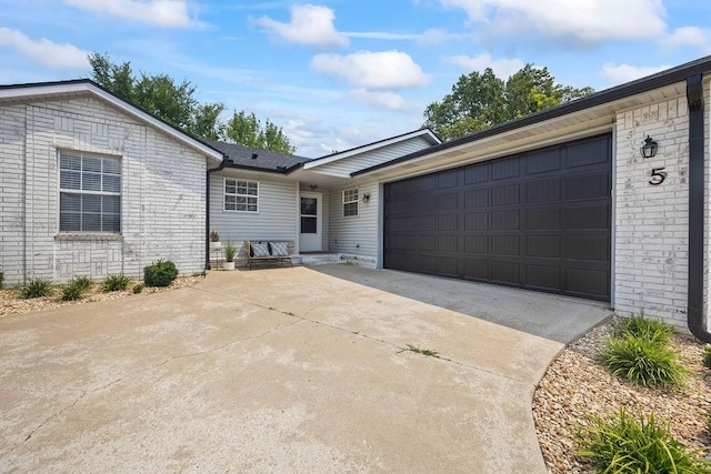 single story home with concrete driveway and an attached garage