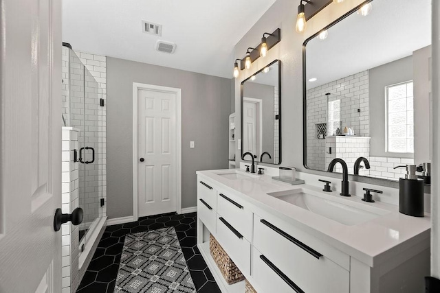 full bath featuring visible vents, a shower stall, a sink, and tile patterned flooring