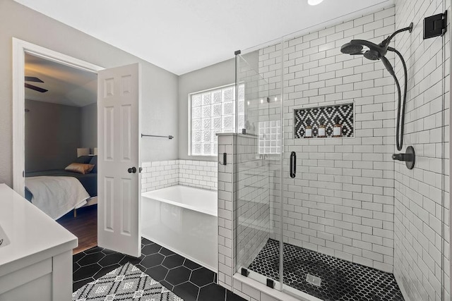 ensuite bathroom with tile patterned flooring, a stall shower, ensuite bath, and a bath